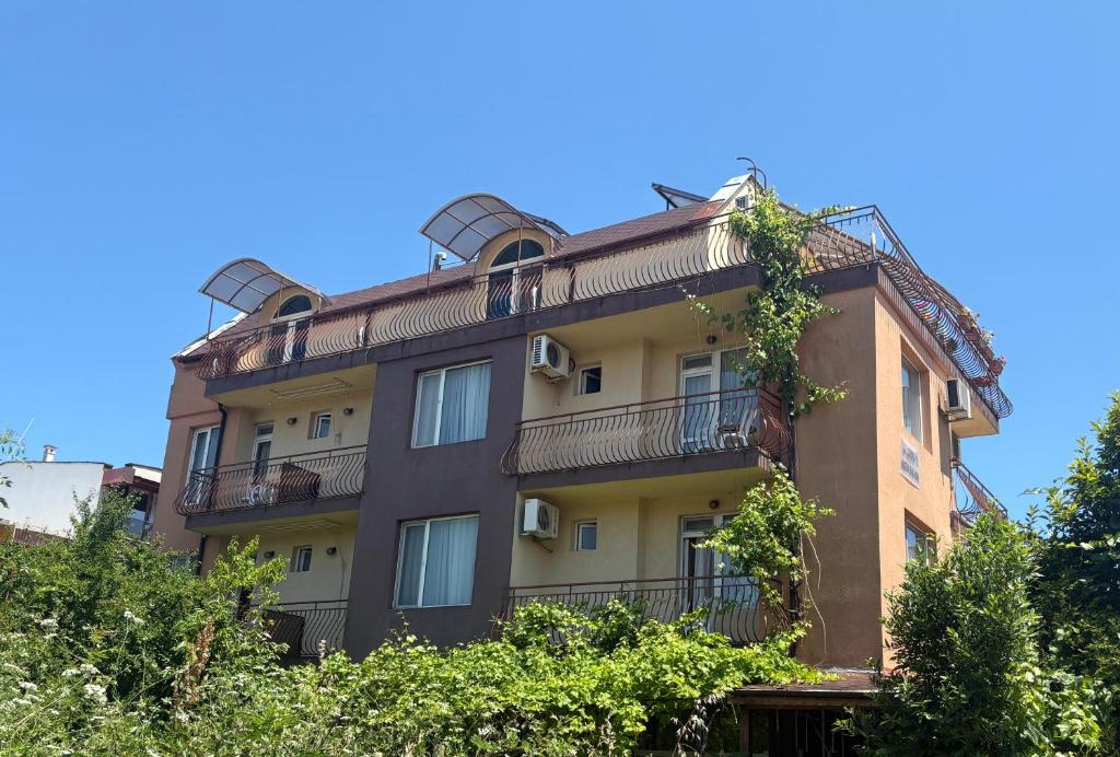 an apartment building with balconies and trees at Rooms Zora in Primorsko