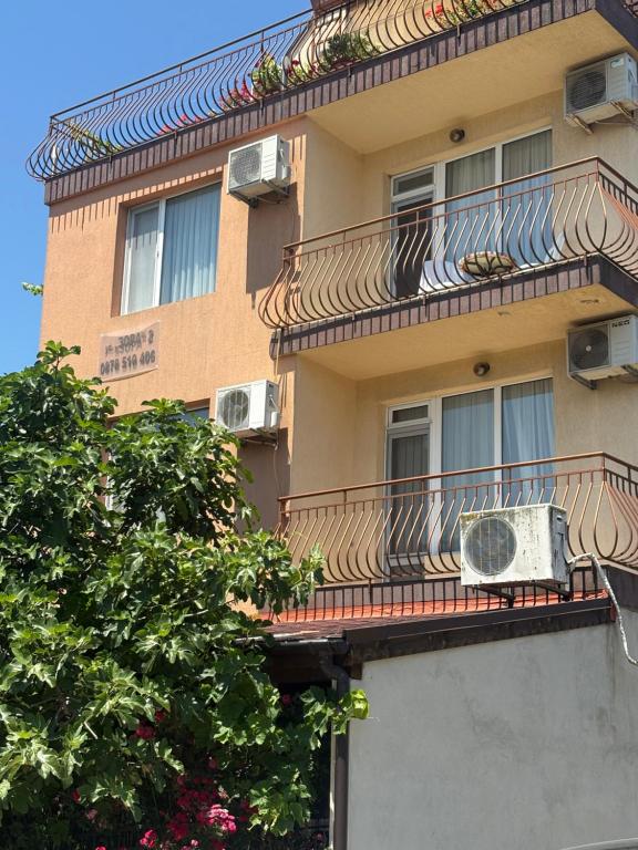 a building with a balcony with an air conditioner on it at Miraj-MD in Primorsko