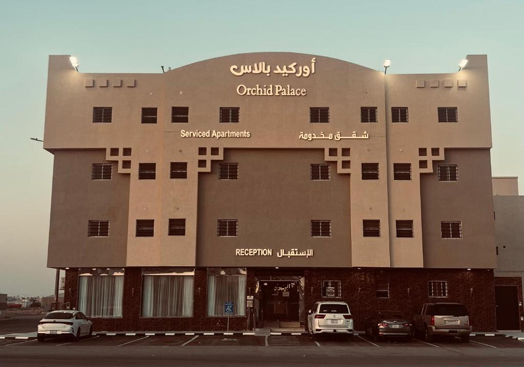 a building with cars parked in front of it at أوركيد بالاس للشقق المخدومة in Riyadh