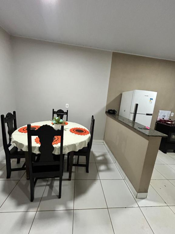a dining room with a table and a refrigerator at Lar doce lar in Barra do Garças