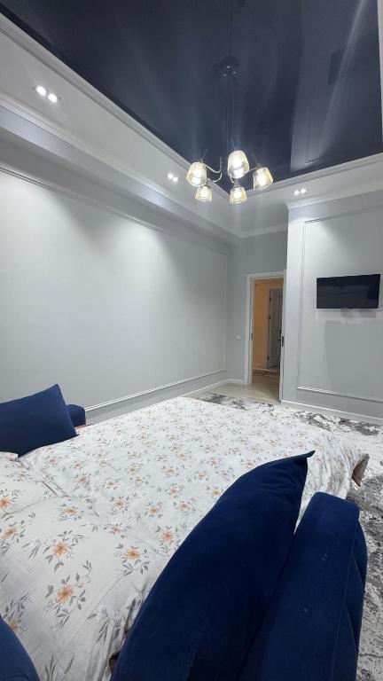 a bedroom with a large bed with blue pillows at Lux apartment in Ak-Tyube