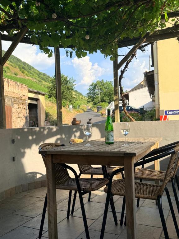 a wooden table with two wine glasses on a patio at Ferienwohnung Alte Metzgerei in Mesenich
