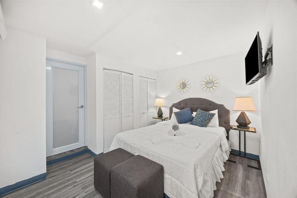 a white bedroom with a bed and a chair at Downtown Studio at San Juan JL Guaynabo in San Juan