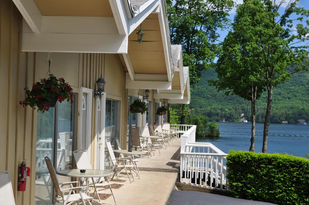 una fila de mesas y sillas al lado de un edificio en Tea Island Resort, en Lake George