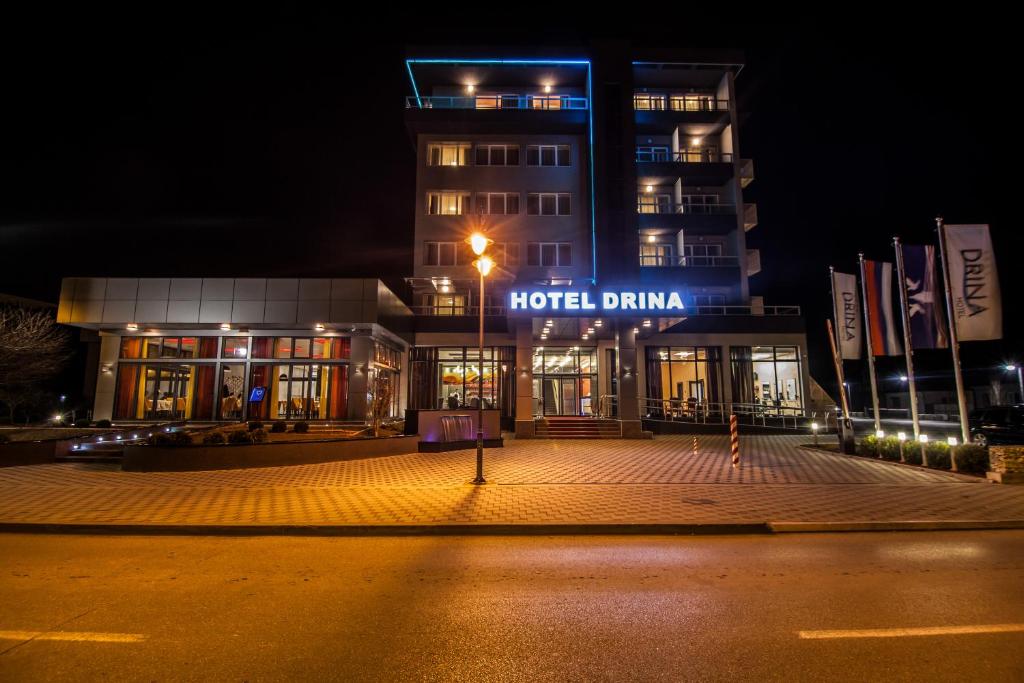 a building with a hotel in the night at Drina Hotel in Bijeljina