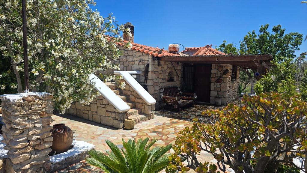 a stone house with a fireplace in a garden at Lekania House in Káto Nisí