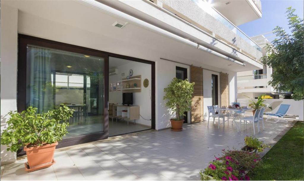 a house with a patio with potted plants on it at Giardino del carrubo in Marina di Ragusa