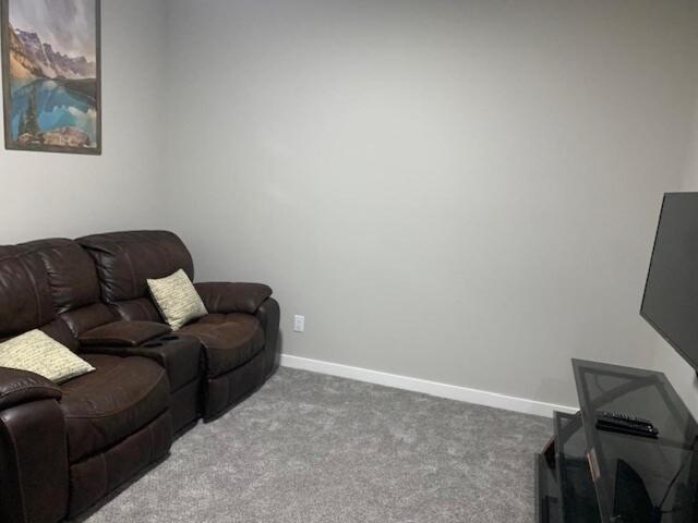 a living room with a brown couch and a television at Karis Home in Airdrie