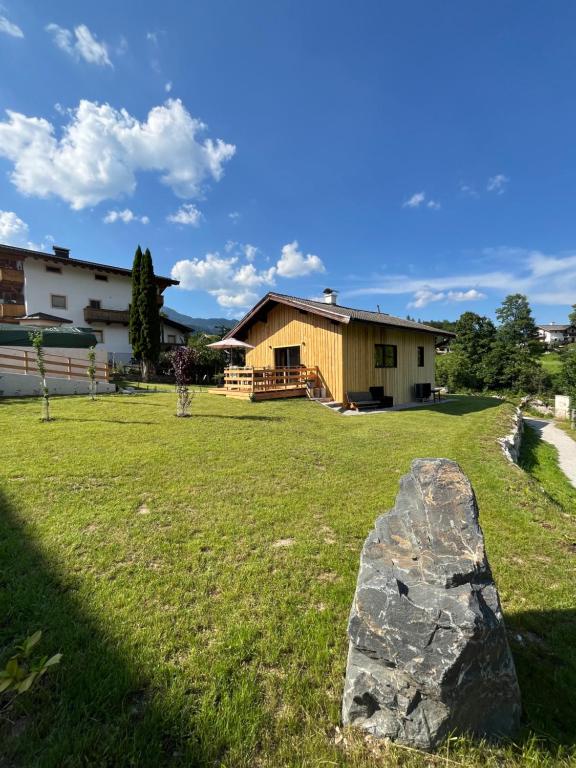 a rock in the grass in front of a house at Saalach Chalet in Lofer