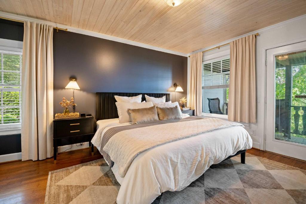 a bedroom with a large bed and two windows at Historic Riverview Inn One in Chattanooga