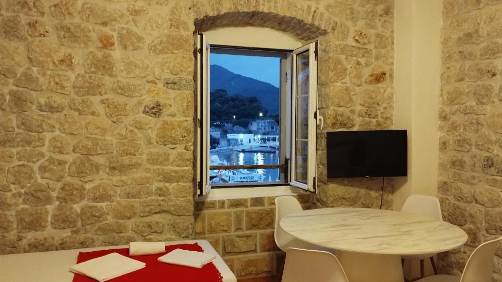 a living room with a table and a window at LaRos Apt in Herceg-Novi