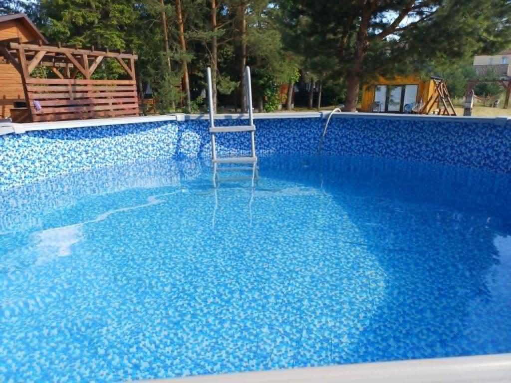 a chair sitting in the middle of a blue swimming pool at U Świstaka in Krasnobród