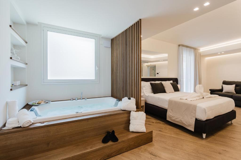 ein Schlafzimmer mit einem Bett und einer Badewanne in einem Zimmer in der Unterkunft Pasitea in Terrasini