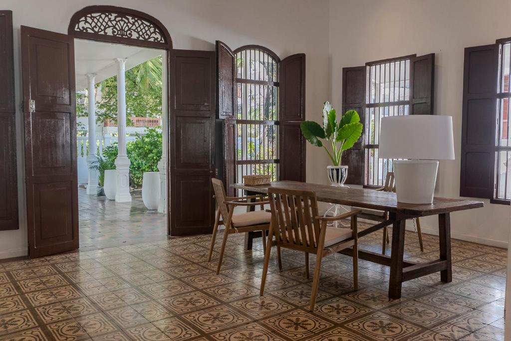 a dining room with a table and chairs and windows at Cabrero House Boutique in Cartagena de Indias