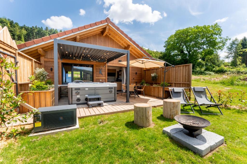 a backyard with a barbecue grill and a house at EPIC CHALETS - 4 et 5 étoiles - Spa privatif - Gérardmer in Granges-Aumontzey