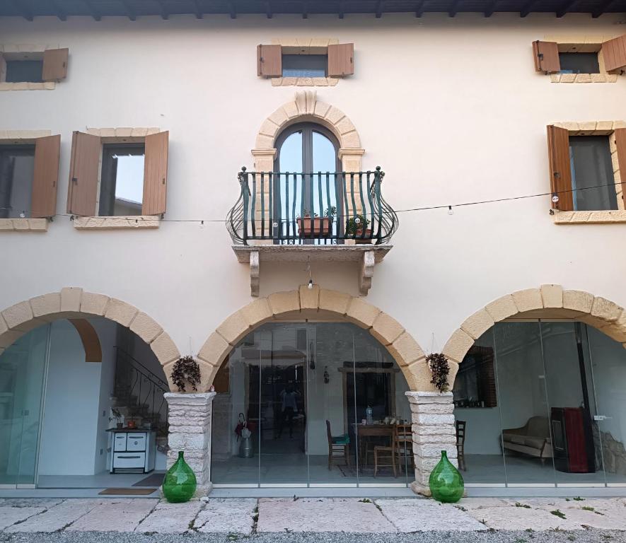 a building with three arches and a balcony at Corte Nascimben in Marano di Valpolicella