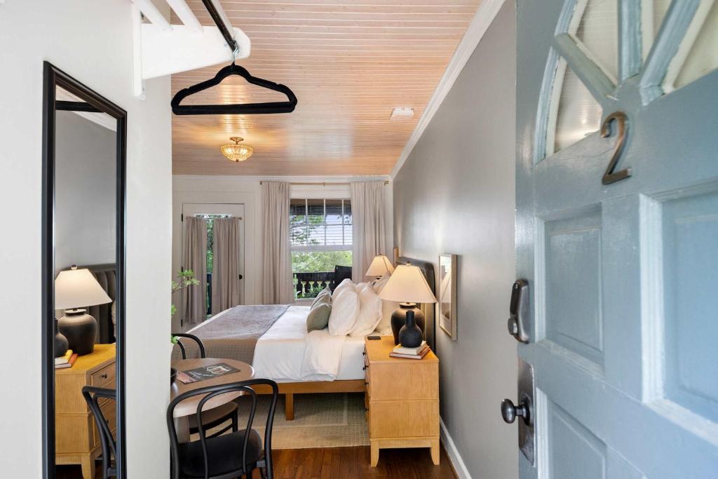a bedroom with a bed and a desk with a mirror at Historic Riverview Inn Two in Chattanooga