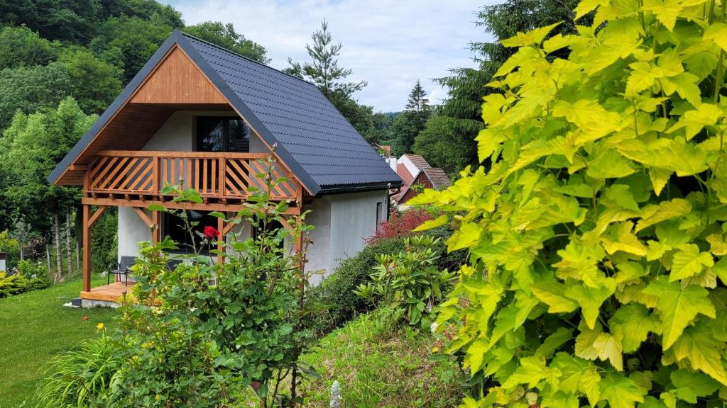 a cottage with a black roof and a garden at Niebo do wynajęcia in Kłodzko