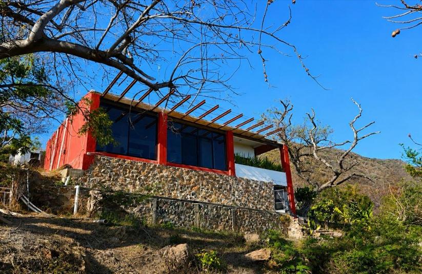 a red house on top of a hill at Abitare Mezcala Residencia in Isla de Mezcala