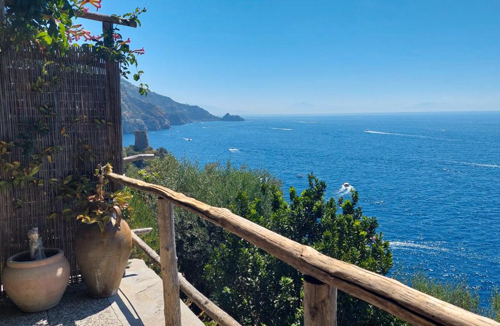 a view of the ocean from a wooden railing at Sea Side Solandra in Praiano