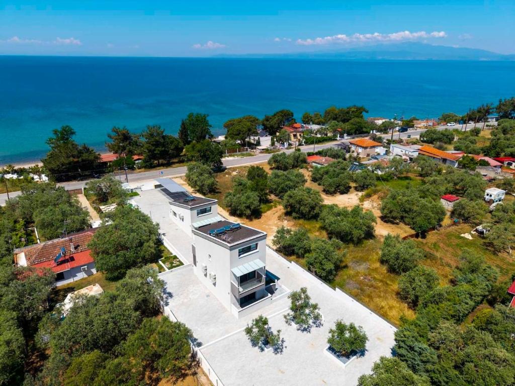 an aerial view of a building with the ocean in the background at Psarras Deluxe Suites in Limenas