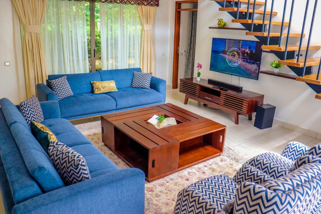 a living room with blue couches and a coffee table at Lihanda Villa in Kilifi