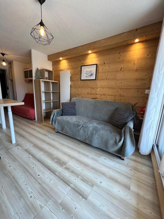 a couch in a living room with a wooden wall at Chaleureux appartement moderne in Briançon