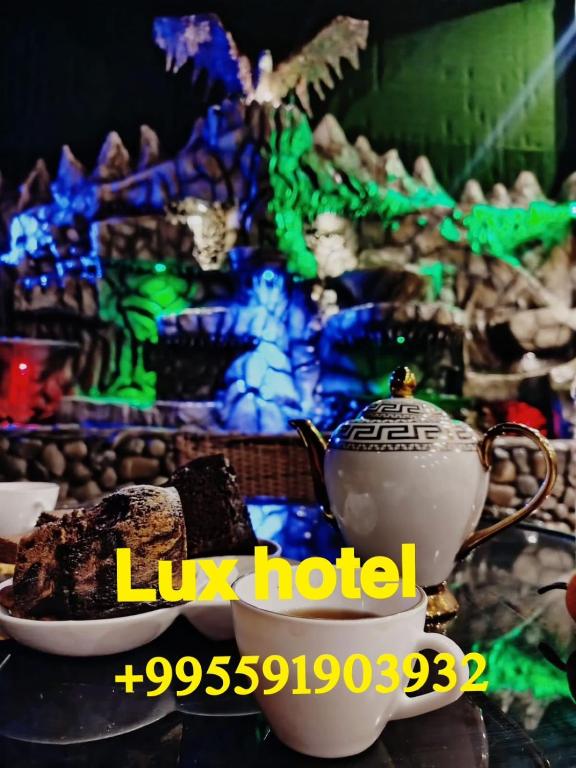 a cup of tea and a piece of cake on a table at Renar Aeraport Lux Hotell in Itʼkhvisi