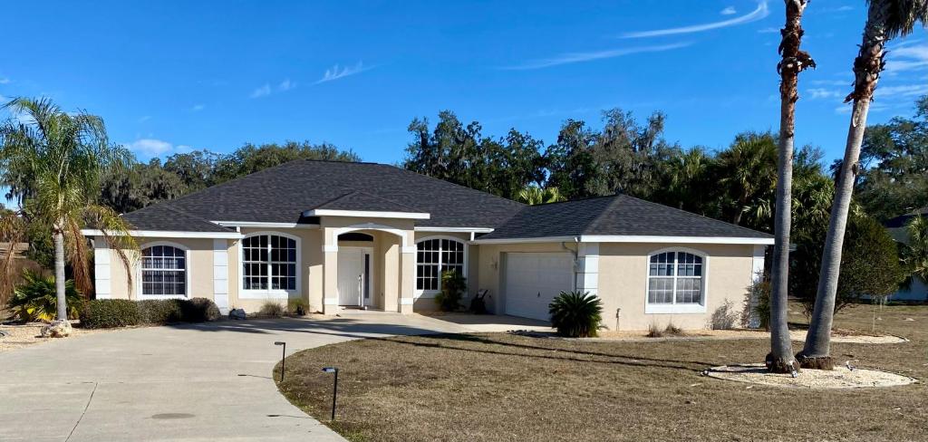 a house with a palm tree in a driveway at Luxury 4BR Pool Home with Jacuzzi- Inverness in Inverness