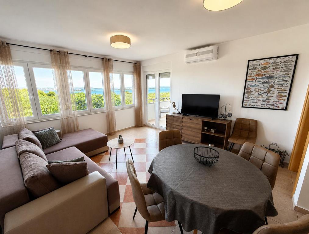 a living room with a couch and a table at Apartman with sea view KAVALA- Pašman, Kraj in Kraj