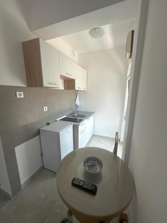 a small kitchen with a table with a remote control on it at UROS apartments in Boreti