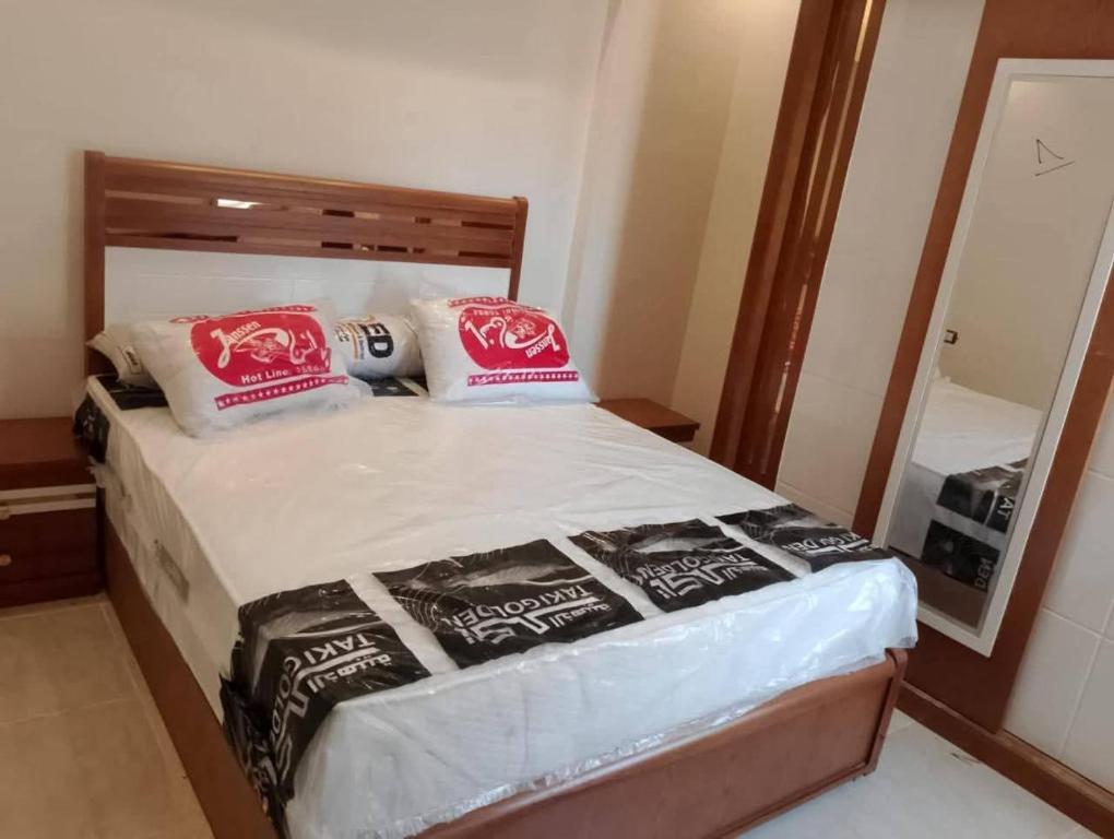 a small bedroom with a bed with a mirror at Sami inn in Al Ghuşnah