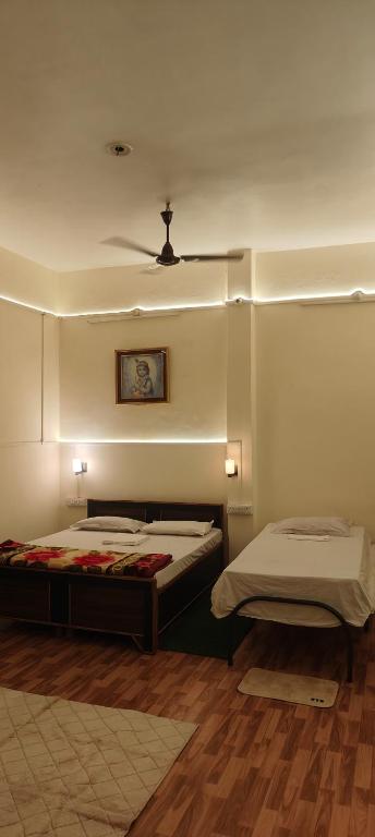 a bedroom with two beds and a ceiling fan at Niyati homestay in Varanasi