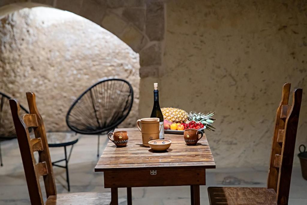 a table with a bottle of wine and fruit on it at Dimora Noè e Concettina in Botrugno