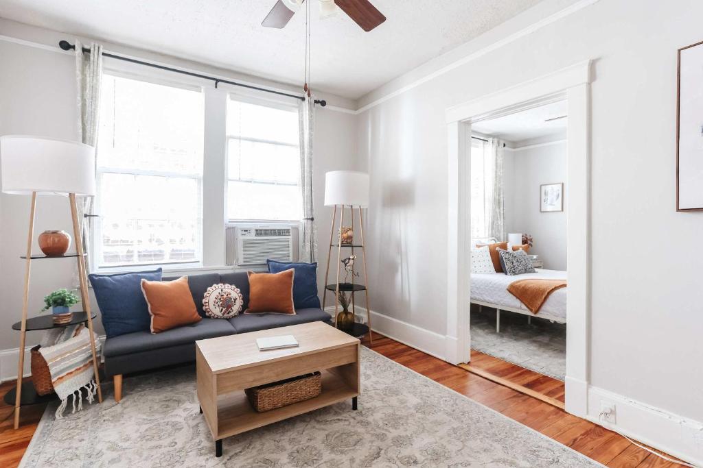 a living room with a blue couch and a bedroom at Oglethorpe Square Historic Apt Central & Walkable in Savannah