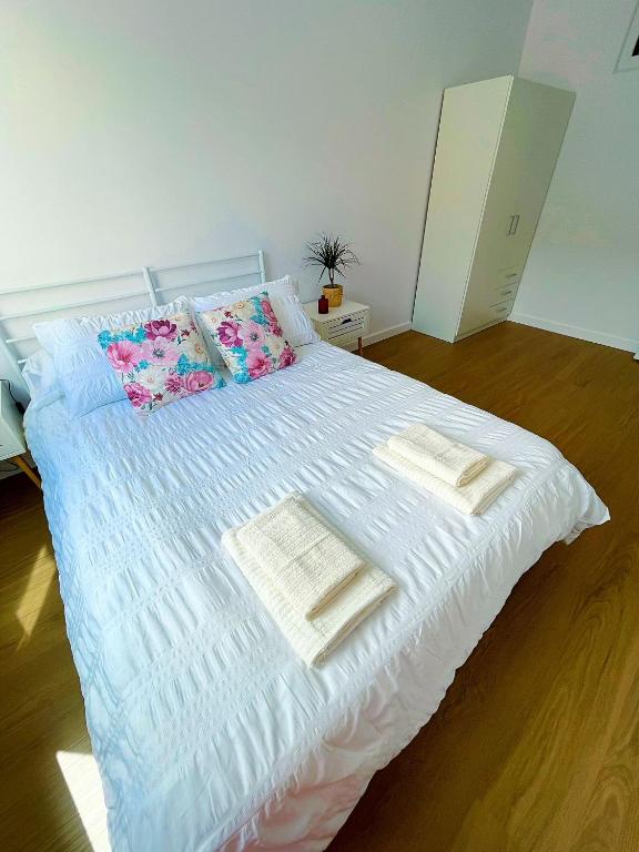 a white bed with pillows and towels on it at Casa Cachú in Baiona