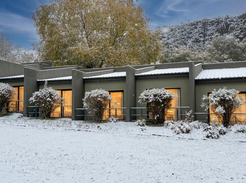 a building with snow on the ground in front of it at Posada del Blanco in Potrerillos