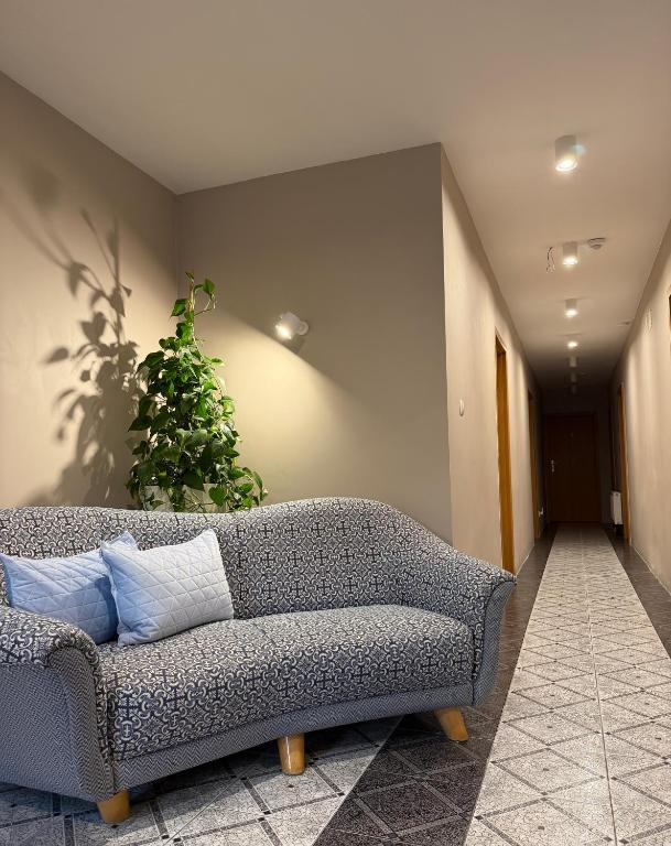a couch sitting in a hallway with a plant at Viking in Dziwnów