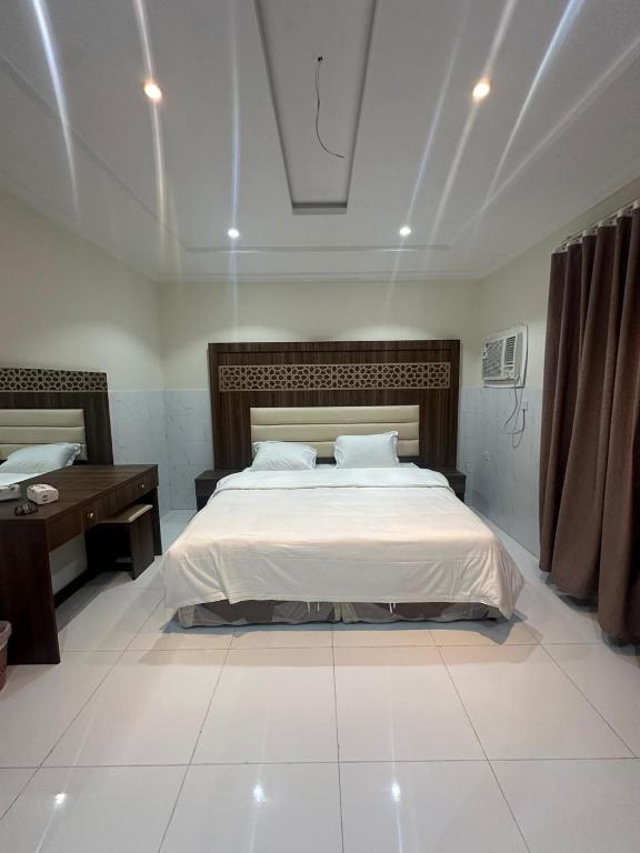 a bedroom with a large bed and a desk at كيان التيسير - حي التيسير in Jeddah