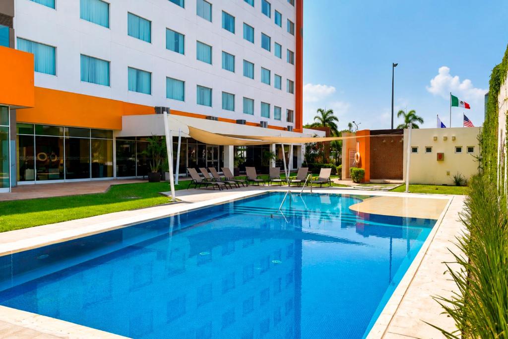a swimming pool in front of a hotel at Hampton Inn & Suites by Hilton Paraiso in Paraíso