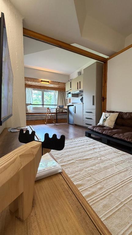 a large living room with a couch and a kitchen at Rifugio Artuik 1400 in Marilleva