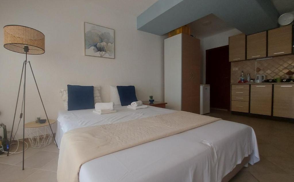 a bedroom with a large white bed with blue pillows at Jadran5 in Petrovac na Moru