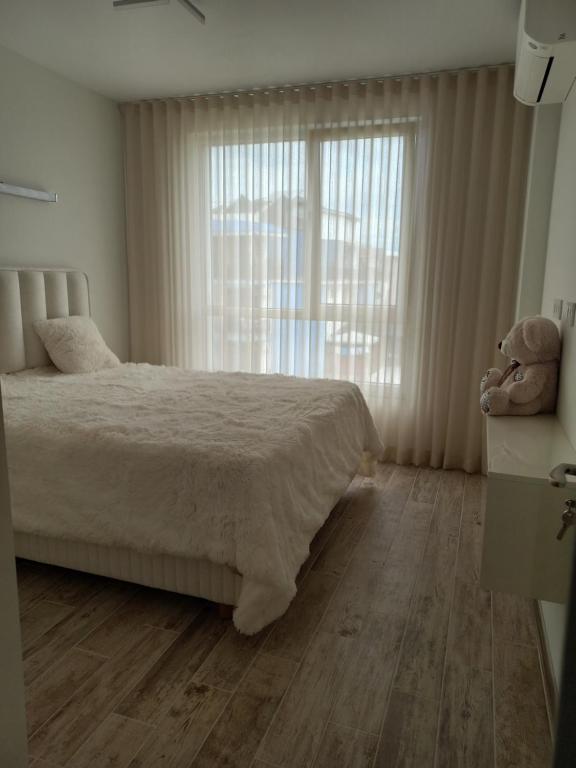 a bedroom with a bed and a teddy bear at Рока Резиденс in Ravda