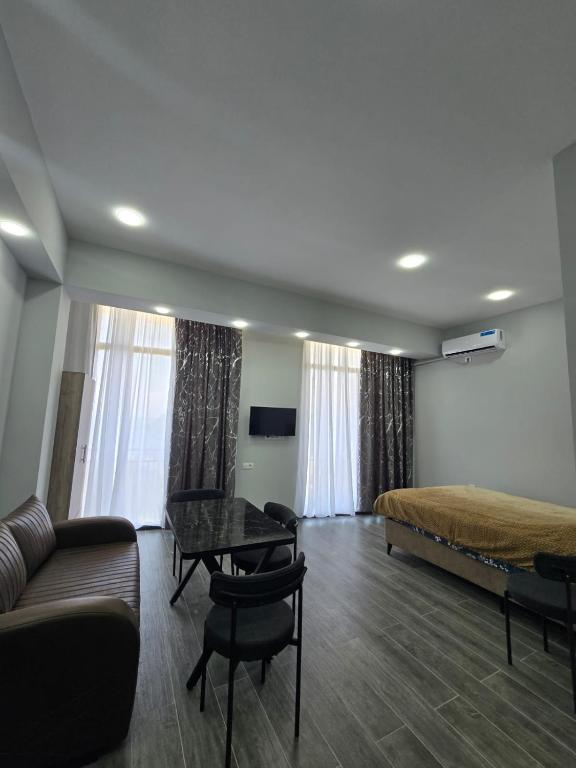 a bedroom with a bed and a couch and a table at Welcome3 in Achʼqva