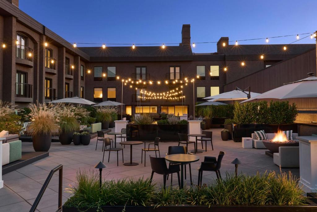 an outdoor patio with tables and chairs and lights at The Satire, Autograph Collection in Alexandria