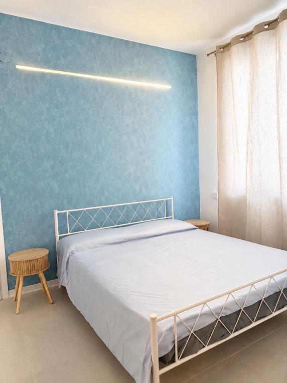 a bedroom with a bed and a blue wall at Marechiaro apartment in Monopoli
