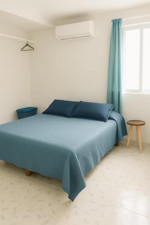 a bedroom with a blue bed and a window at Villa Bonita Torre 11 3 in Cozumel