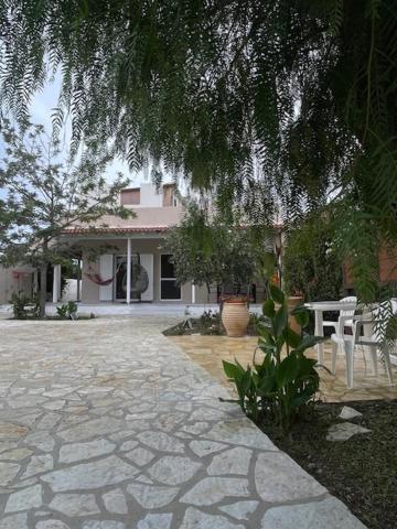 a patio with chairs and a table in front of a house at Ioanna's house in Agios Georgios