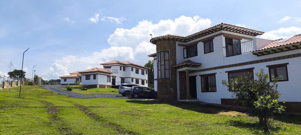 a row of houses with cars parked in a yard at Casas Villa de Leyva in Villa de Leyva
