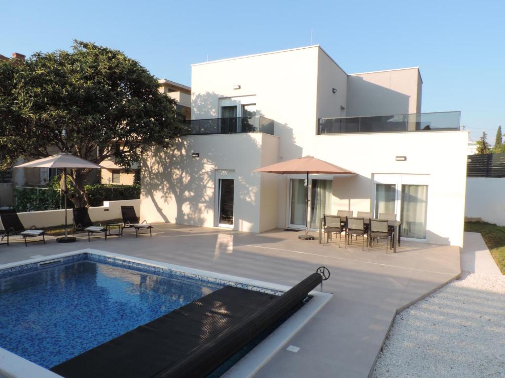 a villa with a swimming pool and a house at Villa RoseMary in Split